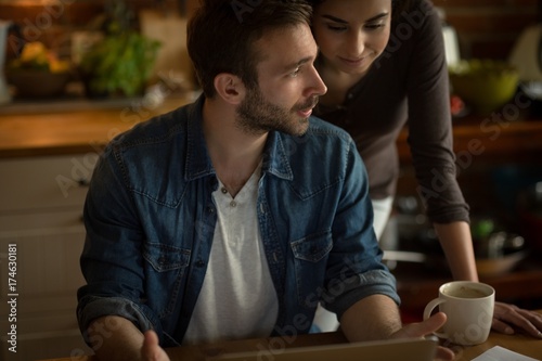 Couple talking while using laptop
