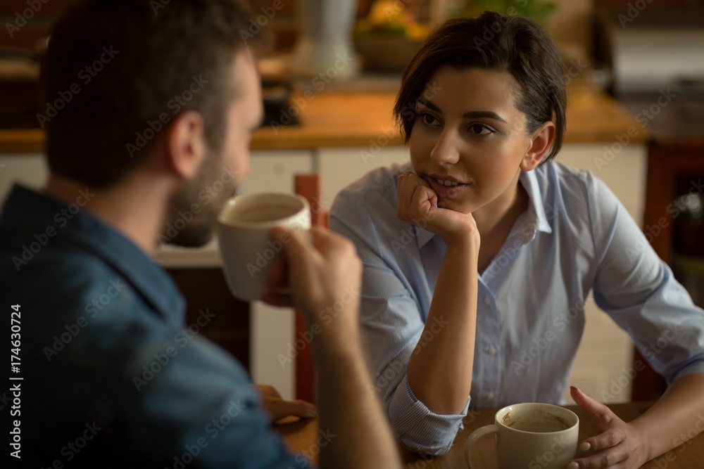 Couple talking while having coffee at table Couple talking while having coffee at table