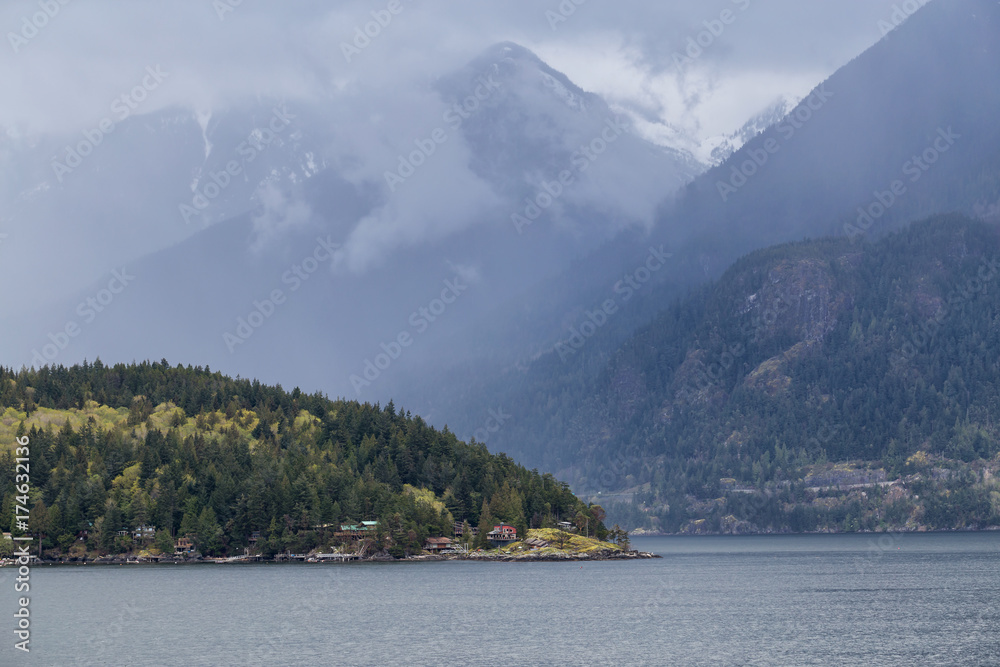 Bowyer Island with the North Shore Mountains in the Background. Picture taken in Howe Sound near Vancouver, British Columbia, Canada, during a gloomy rainy day.