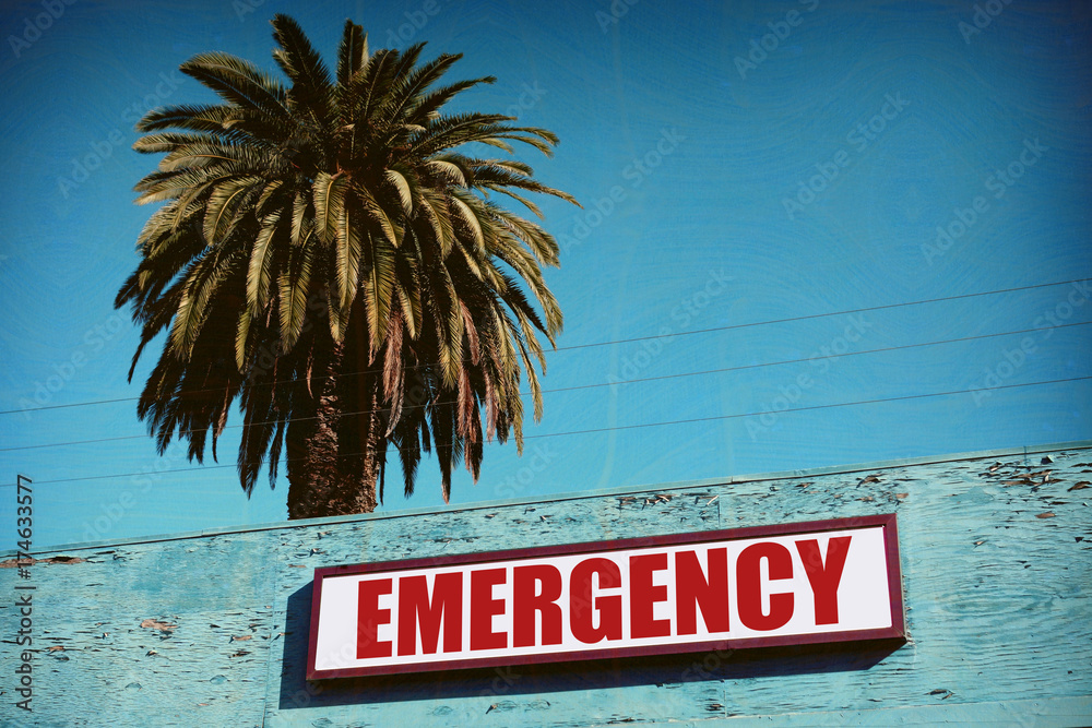 aged and worn vintage emergency sign with palm trees