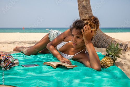 Beautiful woman reading a book at the beach