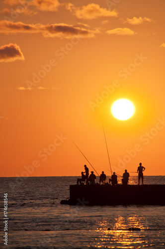  Sunset. Silhouettes of  fishermen. photo