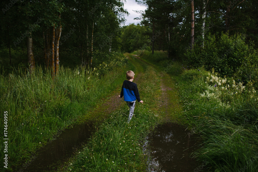 Back of boy dancing as he walks down a beautiful country path. Back of boy dancing as he walks down a beautiful country path.