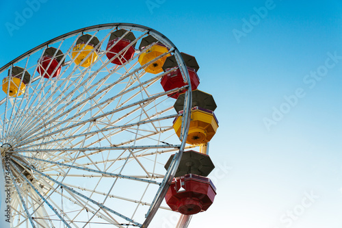 Detail of colourful ferriss wheel against blue sky