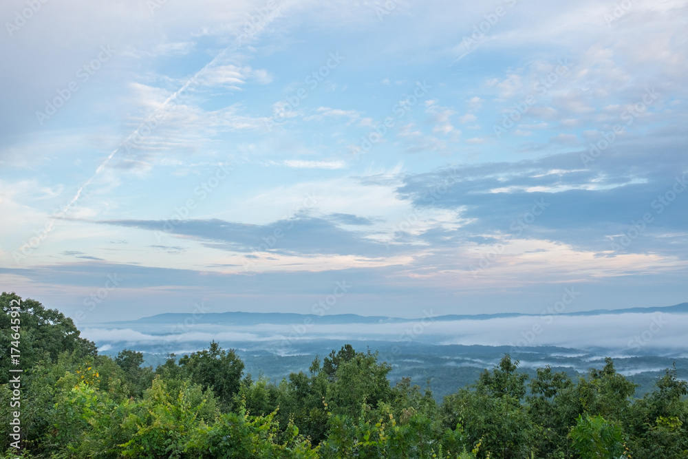 Obraz premium A summer morning look at the foggy hills and valleys near Heflin, Alabama, USA