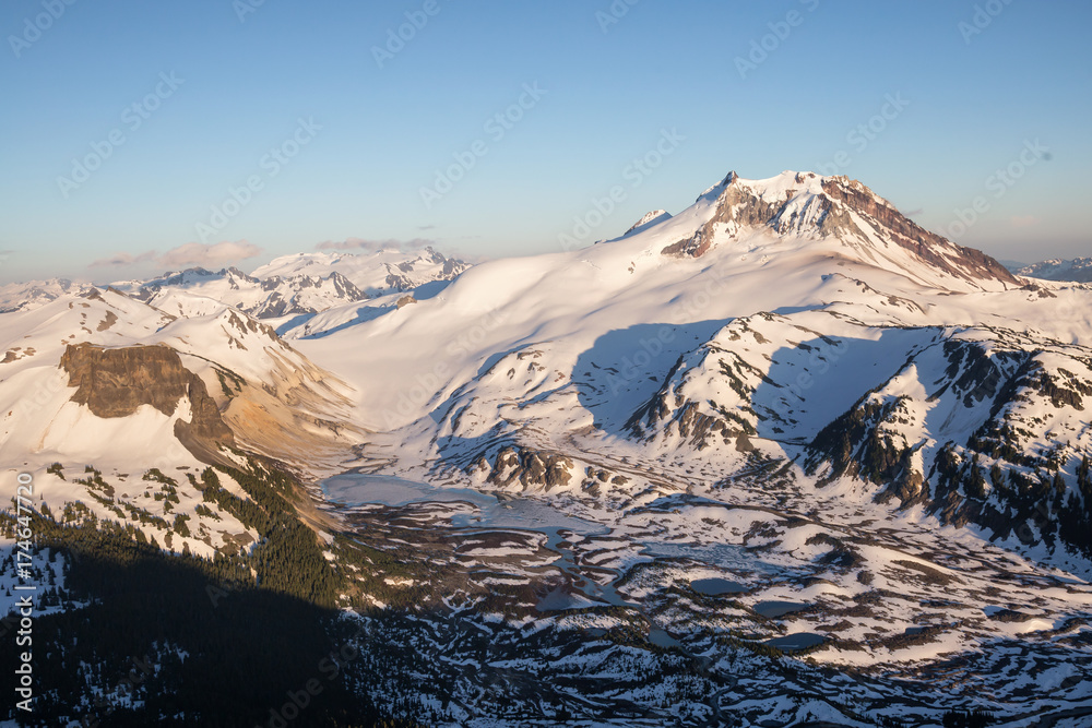 Aerial landscape view of Garibaldi Mountain and Lake still frozen during summer time after a cold winter. Taken near Squamish and Whistler, North of Vancouver, BC, Canada.