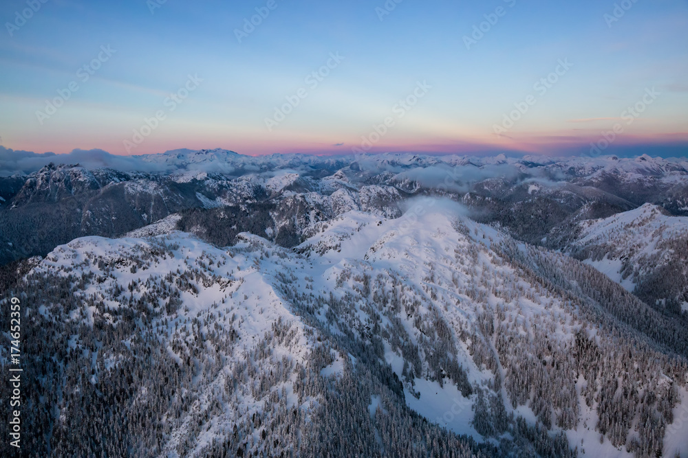 Aerial landscape view of the coastal mountains north of Vancouver, British Columbia, Canada, during a colorful winter sunset. Aerial landscape view of the coastal mountains north of Vancouver, British Columbia, Canada, during a colorful winter sunset.