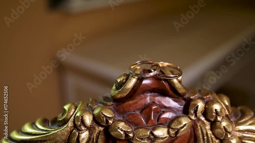 Wedding rings in gold and pearls. Couple wedding rings on old wood texture photo
