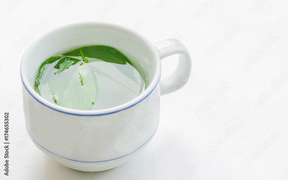 The soft blurred and soft focus cup of green tea, Kariya , The Creat,Andrographis paniculata,Acanthaceae,leaf plant with the white background, natural light shadow reflection. The soft blurred and soft focus cup of green tea, Kariya , The Creat,Andrographis paniculata,Acanthaceae,leaf plant with the white background, natural light shadow reflection.