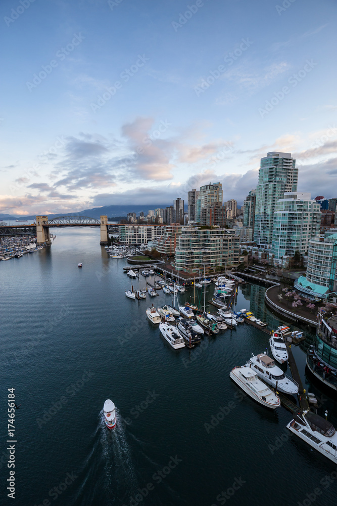 Aerial view on the Downtown Vancouver Buildings during a cloudy morning sunrise. Picture taken in False Creek, British Columbia, Canada. Aerial view on the Downtown Vancouver Buildings during a cloudy morning sunrise. Picture taken in False Creek, British Columbia, Canada.