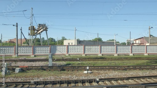 POV: High-speed Train moves past a railway station in the summer photo