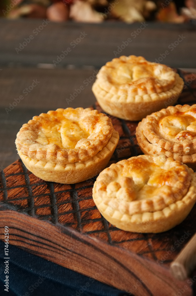 Mini meat pies from flaky dough on a wooden board over wooden background. Mini meat pies from flaky dough on a wooden board over wooden background.