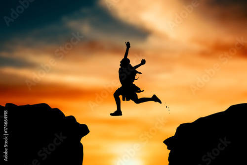 Silhouette of boy jumping at sky sunset