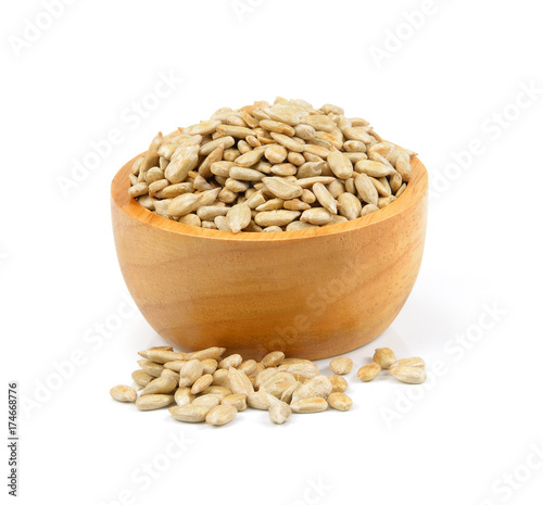 sunflower seeds in a wooden bowl on a white background