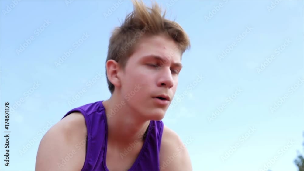 Low angle view of track runner boy teenager preparing to run at starting line, 4k Low angle view of track runner boy teenager preparing to run at starting line, 4k