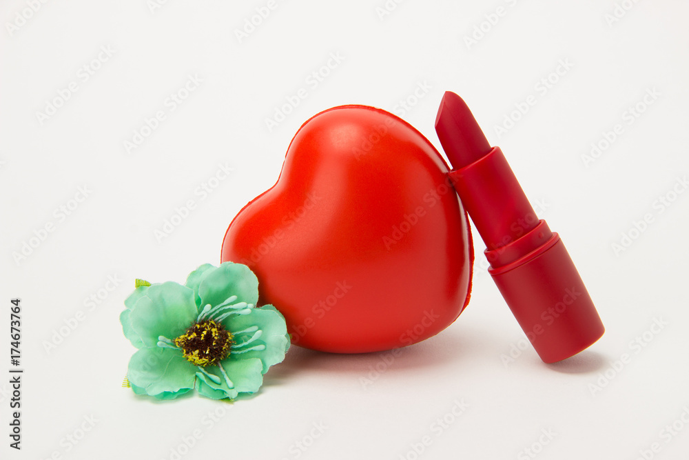 Red lipstick, heart and necklace with flowers on a white background