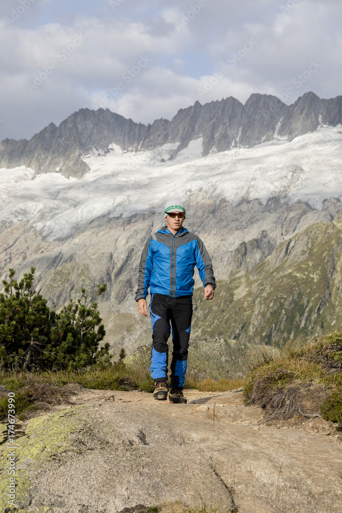 Hiker hikes through a breathtaking alpine landscape in the mountains of Central Switzerland