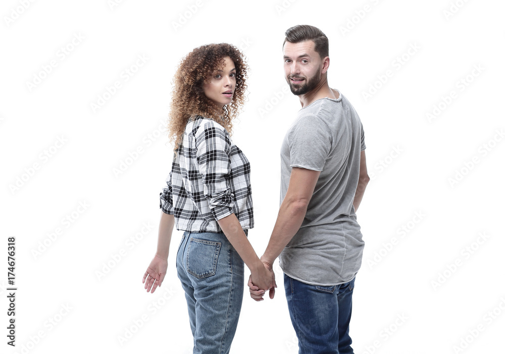 Rear view of happy couple holding hands and looking at camera Rear view of happy couple holding hands and looking at camera