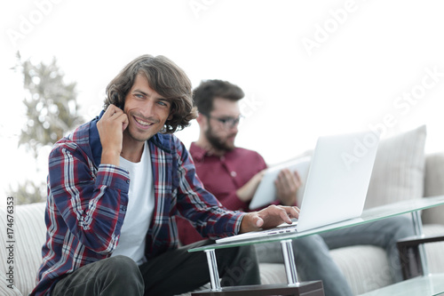 guy with a friend sitting at the desk.