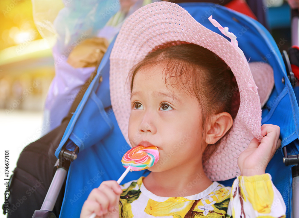 Close-up Beautiful cute little girl wear straw hat eating lollipop. Close-up Beautiful cute little girl wear straw hat eating lollipop.