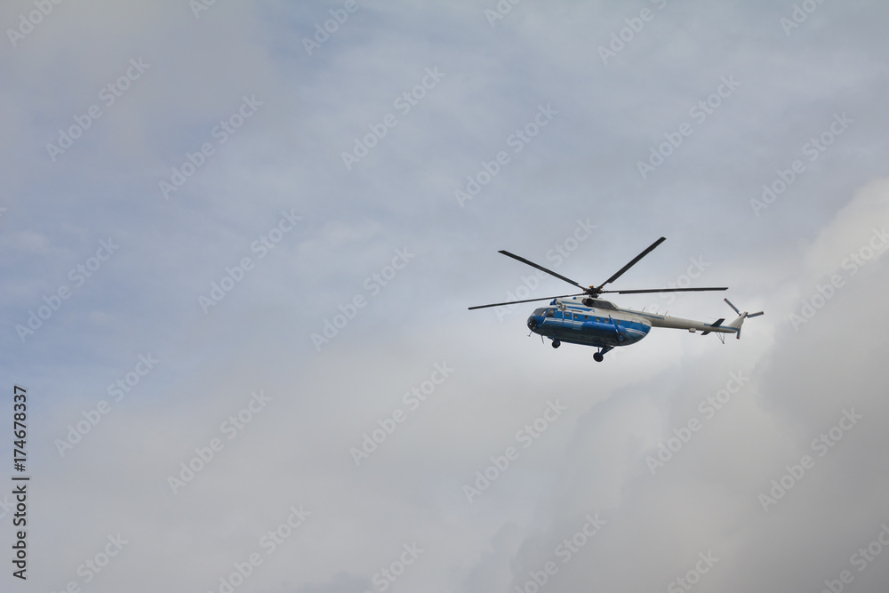 Fototapeta premium Civil helicopter in cloudy sky