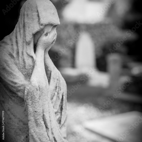 Statue of a sad woman in cemetery photo