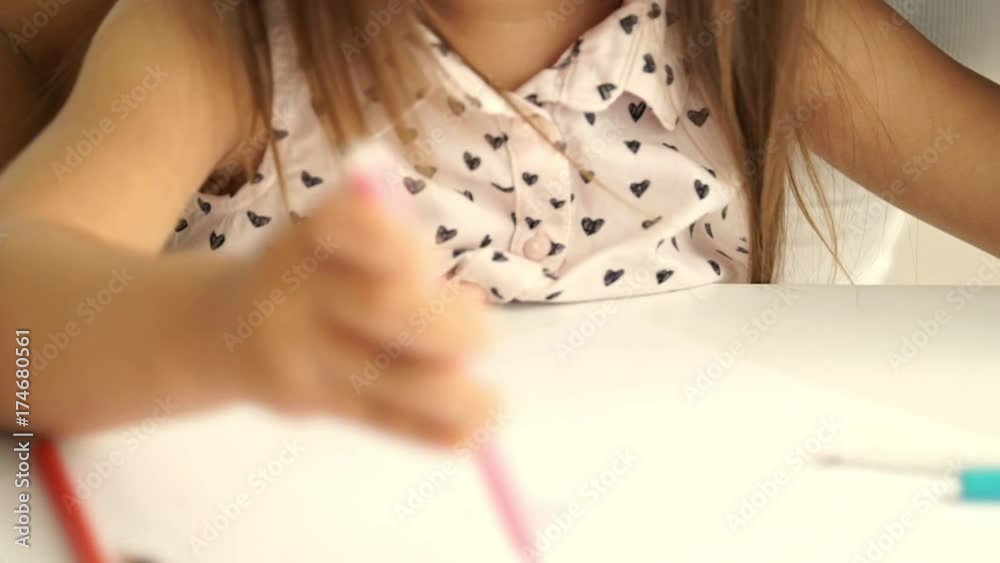 Cropped Close up view of young asian woman sitting by the table with her pretty smiling daughter and draws together Cropped Close up view of young asian woman sitting by the table with her pretty smiling daughter and draws together