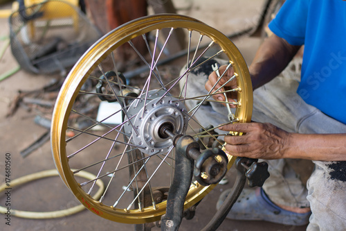 Spoke Adjustment for motorcycles, Truing Spoke Tighten Adjustment, Straightening a motorcycles wheel on a truing stand.  photo