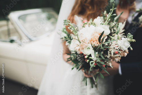 Beauty wedding bouquet with different flowers in hands