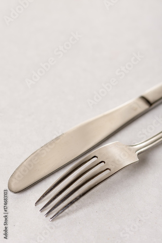 Silverware metal fork and knife on the white marble background with copy space copywritting