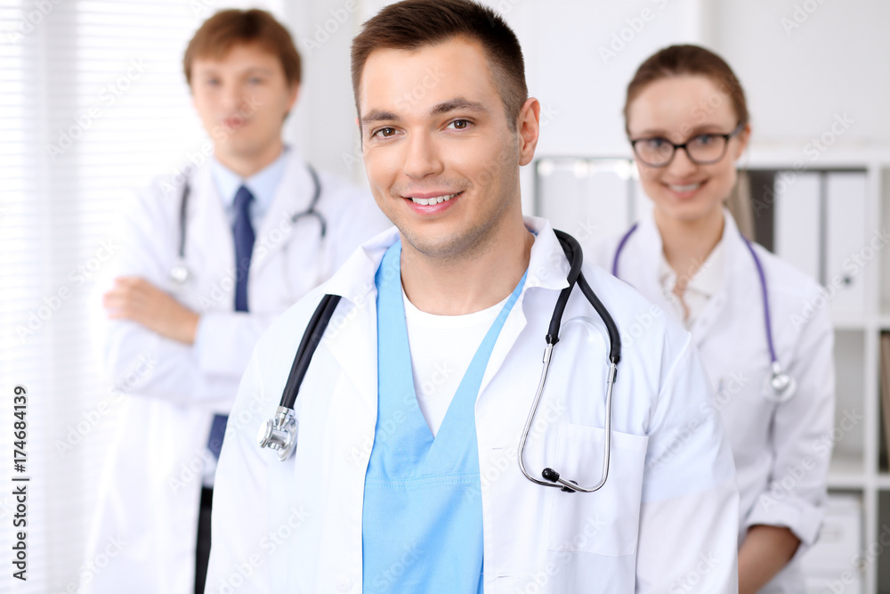 Cheerful smiling male doctor with medical staff at the hospital Cheerful smiling male doctor with medical staff at the hospital