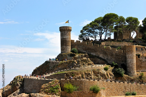 A Senyera estelada, the unofficial flag typically flown by Catalan independence supporters, waving on the tower of Tossa de Mar Fortress, Catalonia, Spain photo