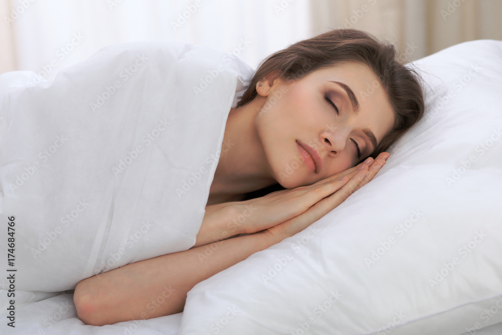 Beautiful young woman sleeping while lying in her bed and relaxing comfortably. It is easy to wake up for work or the day off. Concept of pleasant and rest reinstatement for active life Beautiful young woman sleeping while lying in her bed and relaxing comfortably. It is easy to wake up for work or the day off. Concept of pleasant and rest reinstatement for active life