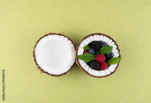 Coconut on green background with berries.