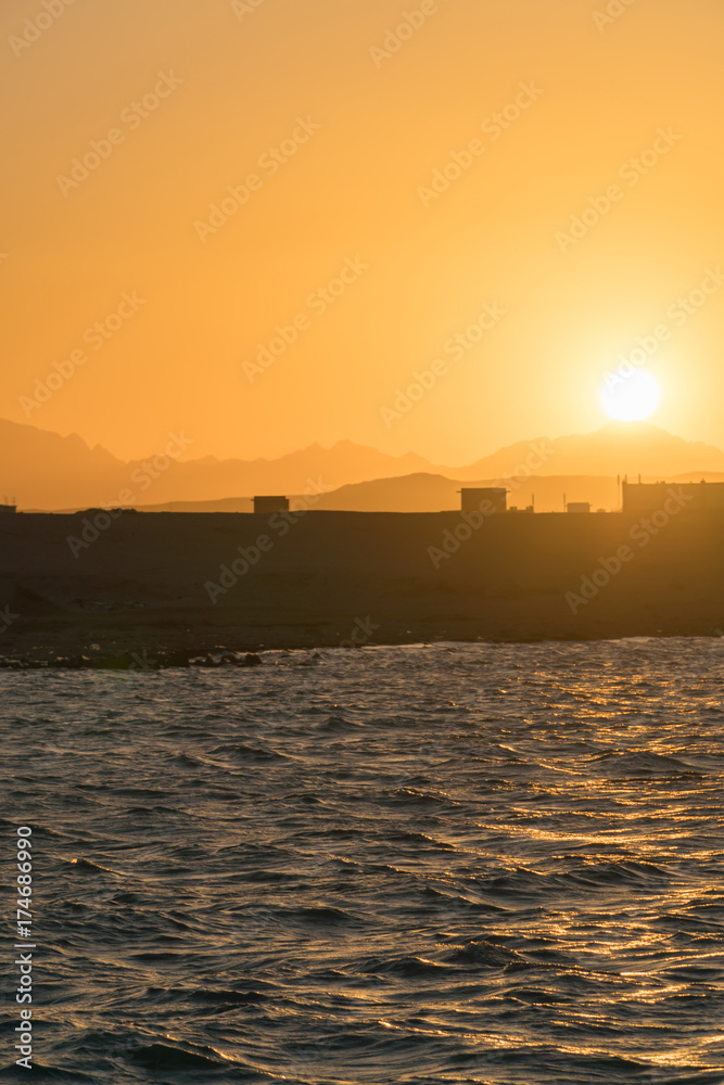 Naklejka premium beautiful sunset on a dirty beach, where the hotel is building