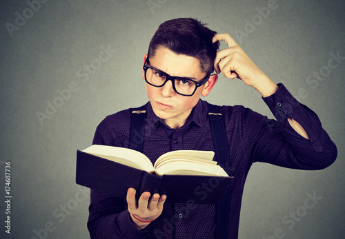 Quadro em tela Confused man in glasses perplexed after reading a book
