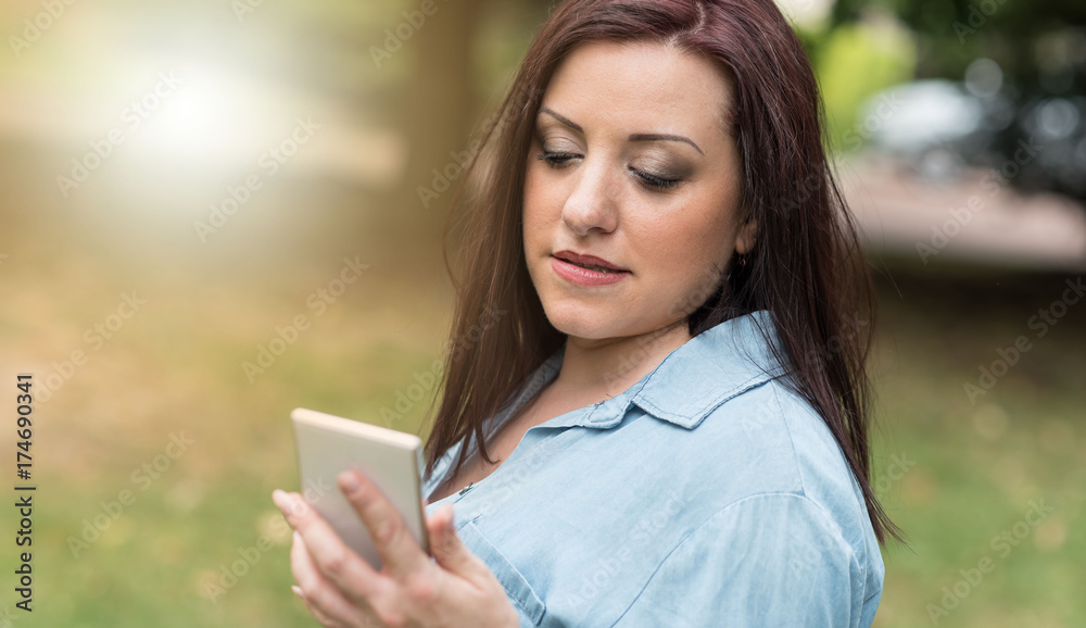 Portrait of young woman using her mobile phone, light effect Portrait of young woman using her mobile phone, light effect