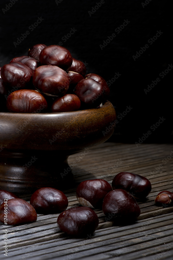 Chestnuts still life art pattern black background dark wood floor corrugated vase Chestnuts still life art pattern black background dark wood floor corrugated vase