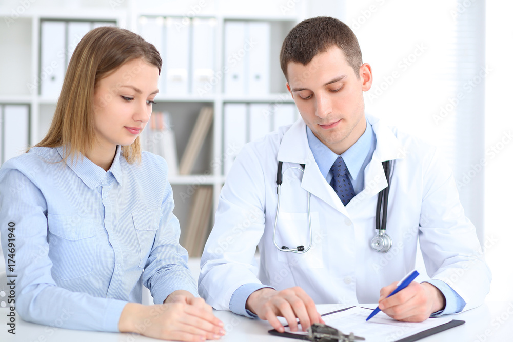 Doctor and patient sitting at the desk. Medicine and health care concept Doctor and patient sitting at the desk. Medicine and health care concept