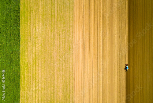Drone view of a farmer plowing his field with his tractor
