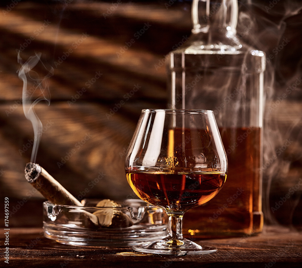 coal Practical graduate Glass of cognac or brandy with smoking cigar on wooden table Stock Photo |  Adobe Stock