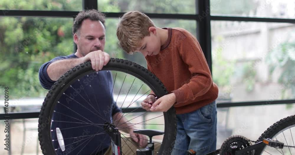 Father teaching Son how to pump bike tyres Father teaching Son how to pump bike tyres