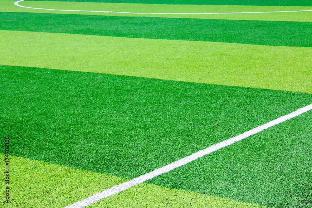Obraz premium Photo of a green synthetic grass sports field with white line shot from above