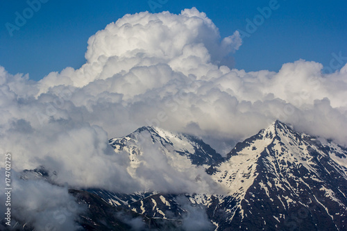 large white clouds stuck on mountain tops photo