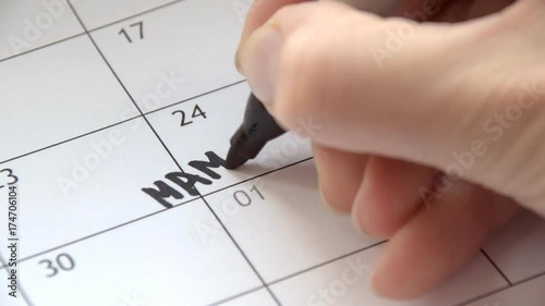 Writing MAMMOGRAPHY on calendar with a black marker