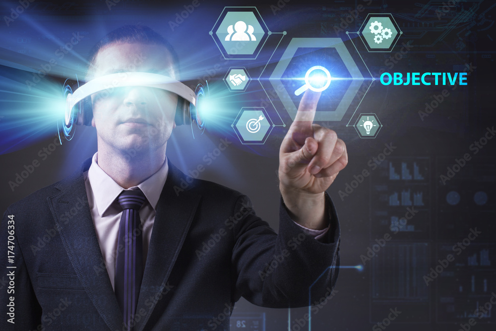 Business, Technology, Internet and network concept. Young businessman working in virtual reality glasses sees the inscription: Objective Business, Technology, Internet and network concept. Young businessman working in virtual reality glasses sees the inscription: Objective