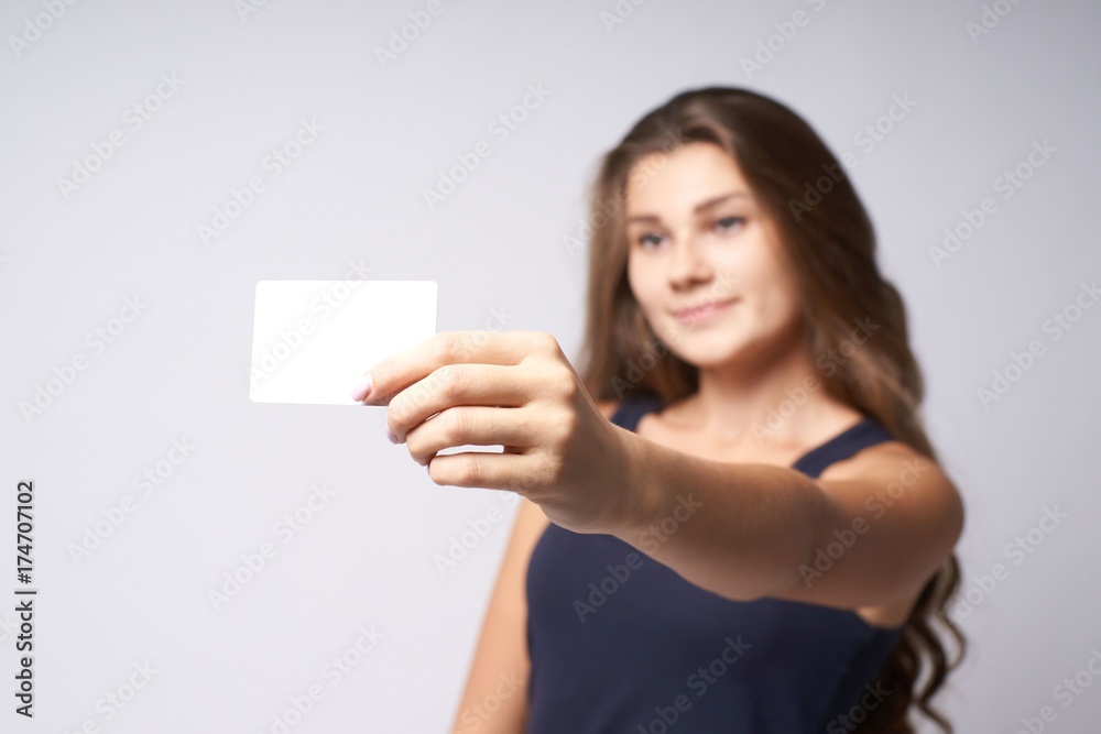 White card. Portrait girl. Blurred background. Arm White card. Portrait girl. Blurred background. Arm