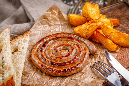 Spiral sausage grilled. with golden crispy delicious french fries. Fast food in the restaurant. Delicious fried spiral sausages.