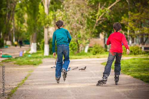 Three children on in line skates in park