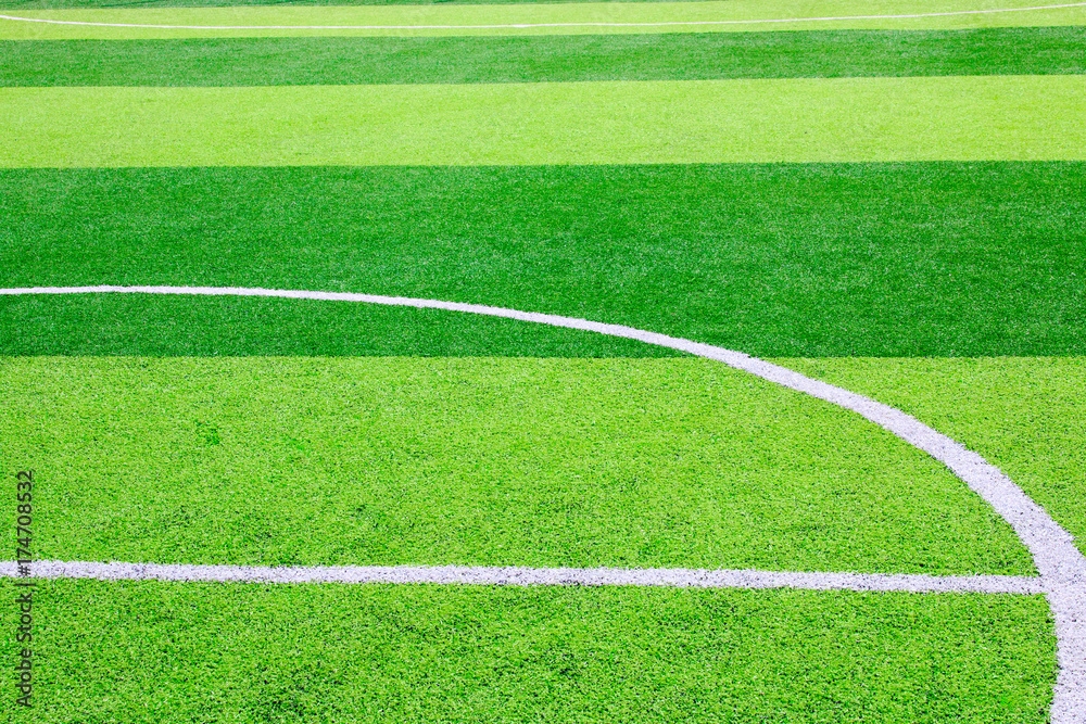 Obraz premium Photo of a green synthetic grass sports field with white line shot from above
